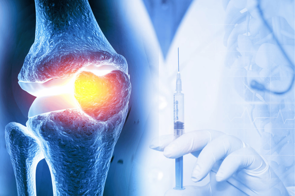 A woman lies in bed under a beige duvet, looking tired or unwell. Her right hand rests on her forehead, and she has a thoughtful expression. The setting appears to be a dimly lit bedroom with matching pillows.