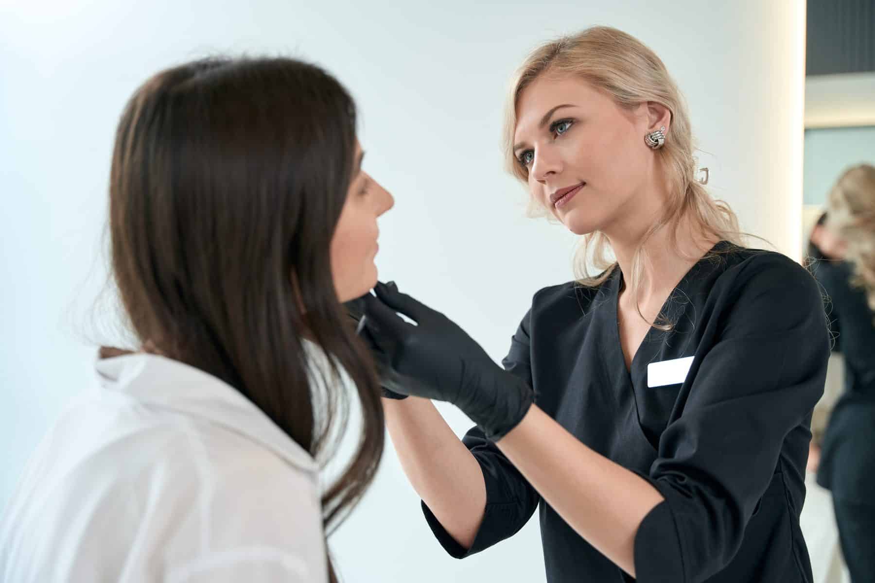 Aesthetic practitioner assessing a woman's face before anti-wrinkle treatment