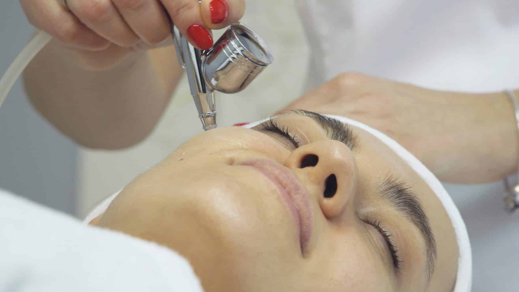 Woman receiving a JetPeel oxygen facial treatment at a skin clinic